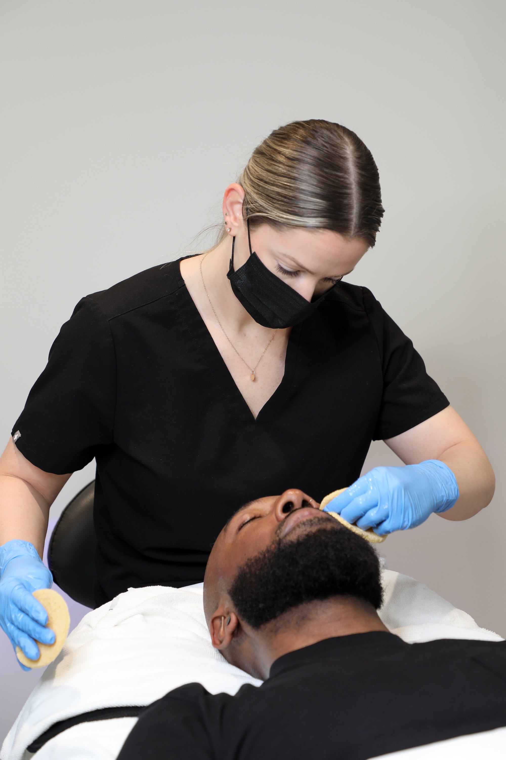 provider wiping man's face with pads