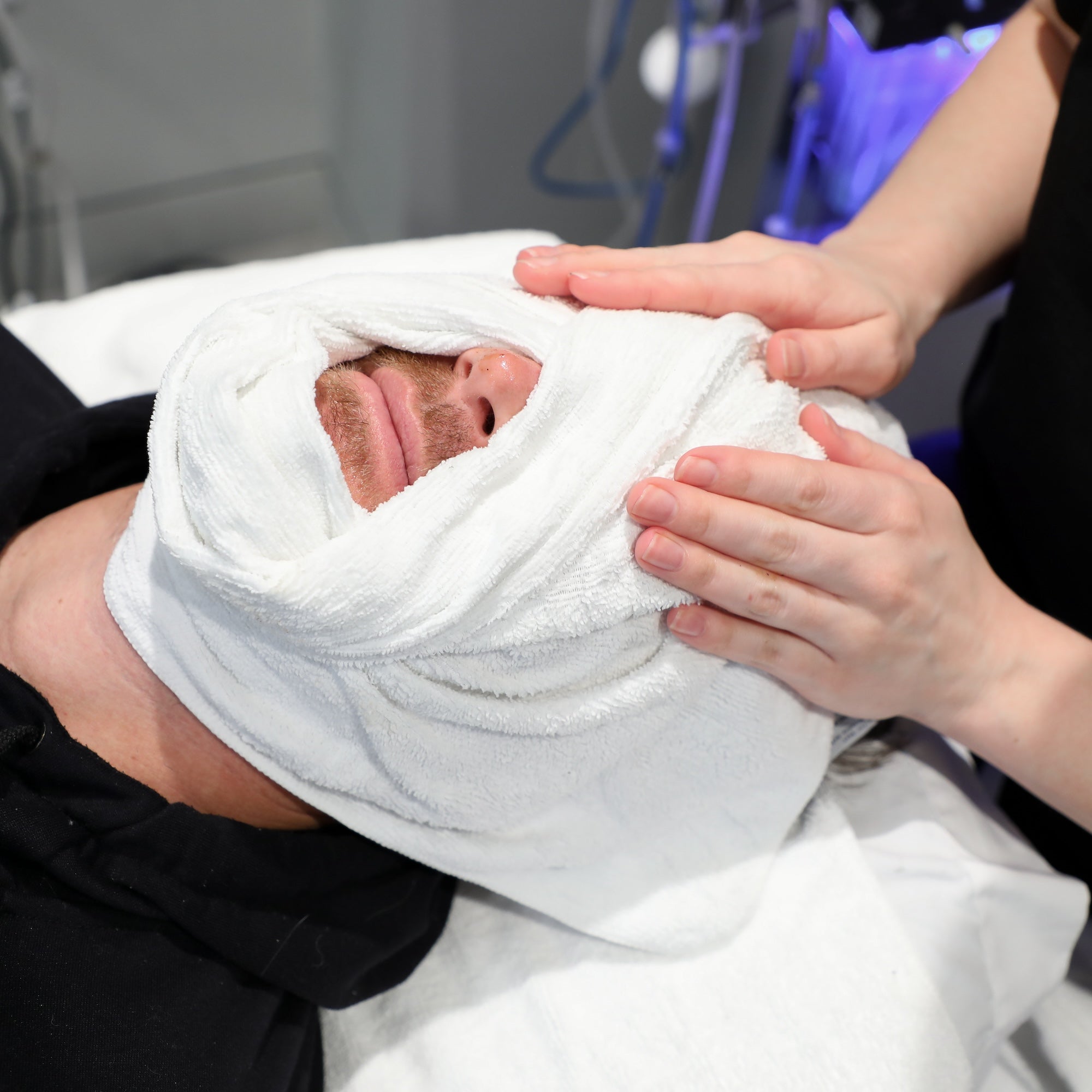 man's face in towel during treatment