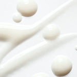 Close-up of complexion brightening serum droplets on a white background