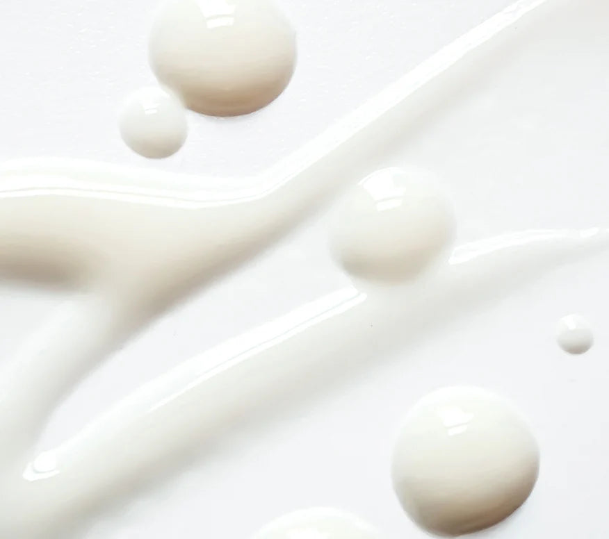 Close-up of complexion brightening serum droplets on a white background