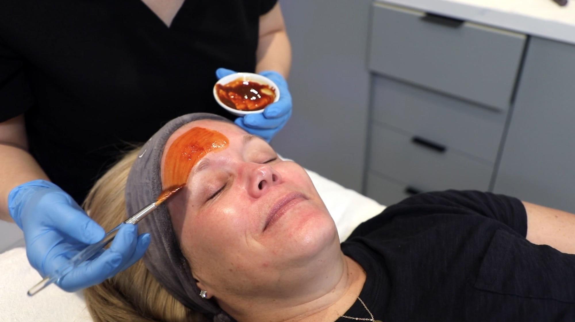 provider applying facial substance to patient face